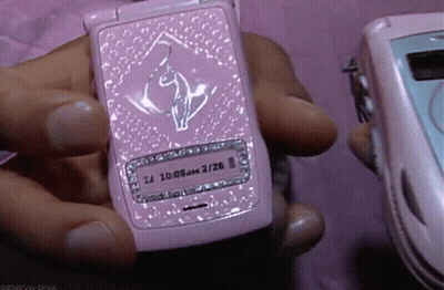 A Person Holding A Pink Flip Phone That Says 10:08 Am On It GIF