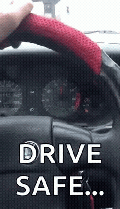 A Person Holding A Red Steering Wheel With The Words Drive Safe Written On It GIF