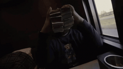 A Person Holding A Stack Of 20 Dollar Bills In Front Of A Window GIF