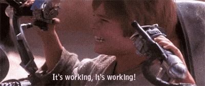A Person Holding A Steering Wheel With The Words " It 'S Working It 'S Working " Above Them GIF