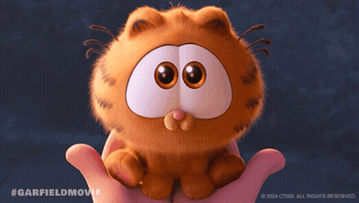 A Person Holding A Stuffed Garfield Cat With A Nut In Its Mouth GIF