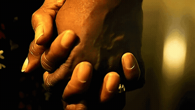 A Person Holding Another Person 'S Hand In A Dark Room GIF