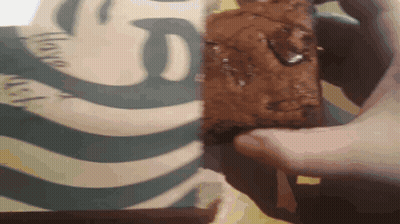 A Person Holds A Brownie In Front Of A Starbucks Logo GIF