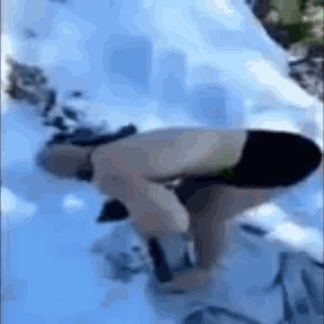 A Person In A Bikini Is Bending Over In The Snow GIF