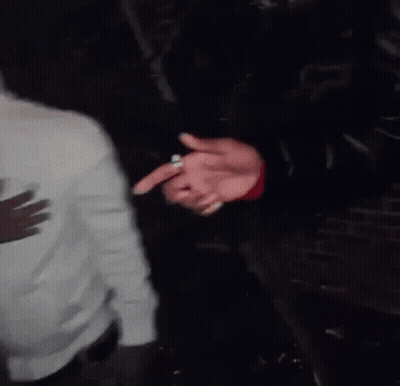 A Person In A Black Leather Jacket Is Holding Another Person 'S Hand GIF