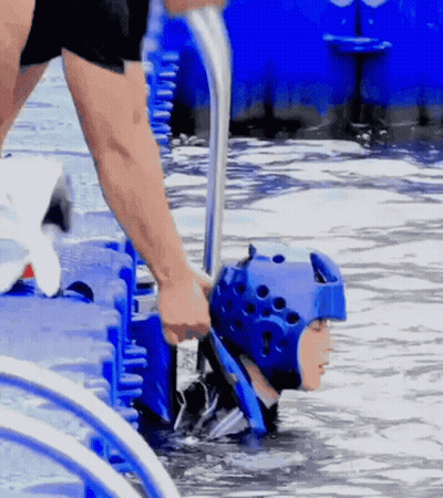 A Person In A Blue Helmet Is Being Pulled Out Of The Water GIF
