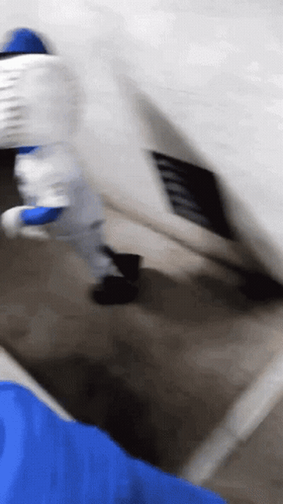A Person In A Blue Shirt Is Holding A White Object GIF