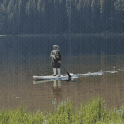 A Person In A Boat On A Lake In The Mountains GIF