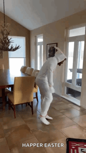 A Person In A Bunny Costume Is Dancing In A Living Room With The Words " Happier Easter " On The Bottom GIF