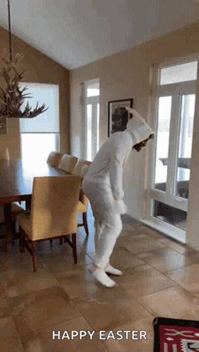 A Person In A Bunny Costume Is Dancing In A Room With The Words Happy Easter Below Them GIF