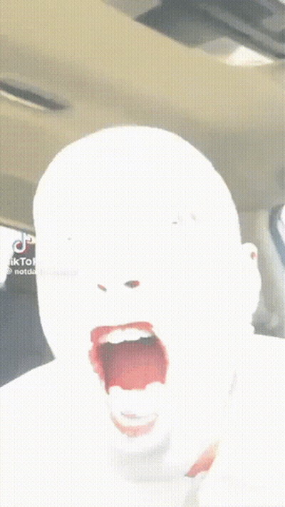 A Person In A Car With Their Mouth Open And Their Tongue Hanging Out GIF