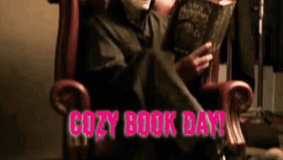 A Person In A Chair Reading A Book With The Words Cozy Book Day In Pink GIF
