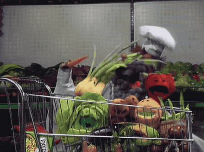 A Person In A Chef 'S Hat Pushes A Shopping Cart Full Of Vegetables GIF