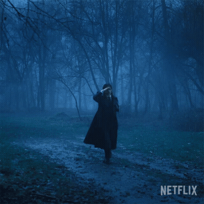 a person in a dark forest with a netflix logo on the bottom right