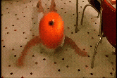 A Person In A Diaper Is Laying On The Floor With A Pumpkin On Their Head . GIF