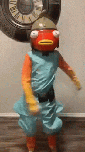 A Person In A Fish Costume Is Dancing In Front Of A Large Clock . GIF