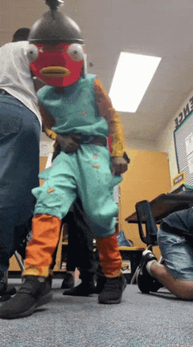 A Person In A Fish Costume Is Standing In A Classroom With The Word Evidence On The Wall GIF