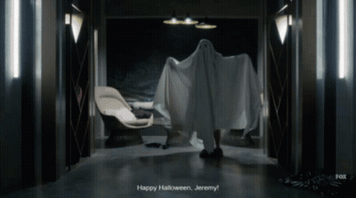 A Person In A Ghost Costume Says " Happy Halloween Jeremy " In A Dark Hallway GIF