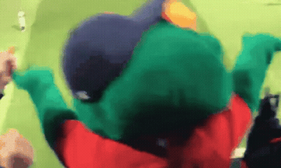 A Person In A Green Frog Costume Is Laying On The Ground GIF