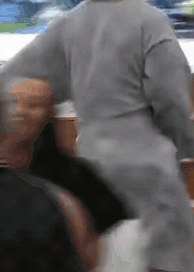 A Person In A Grey Sweater Is Standing Next To Another Person In A Black Shirt . GIF
