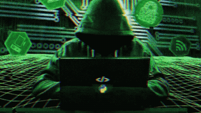 A Person In A Hoodie Is Sitting In Front Of A Laptop Computer GIF