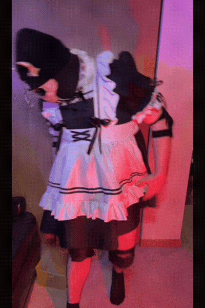 A Person In A Maid Costume Is Standing In A Room With Red Lights GIF