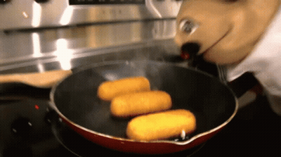 A Person In A Mickey Mouse Costume Is Cooking Food In A Frying Pan GIF