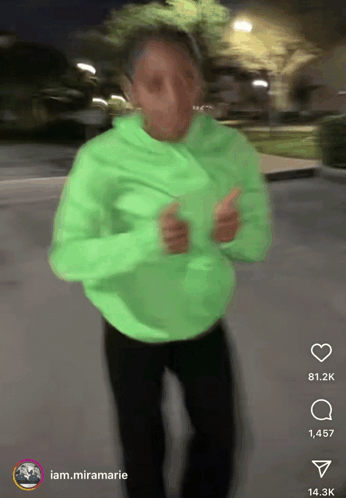 A Person In A Neon Green Hoodie Is Dancing In A Blurry Photo With A Caption That Says Iam.miramarie GIF
