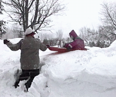 A Person In A Pink Hooded Jacket Is Sledding Down A Snow Covered Hill GIF