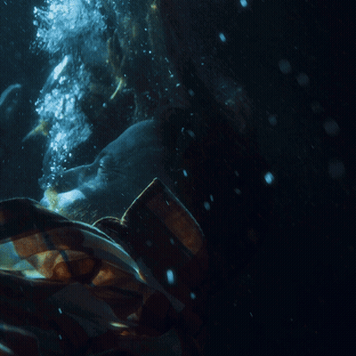 A Person In A Plaid Shirt Is Underwater With Bubbles Coming Out Of Their Mouth GIF