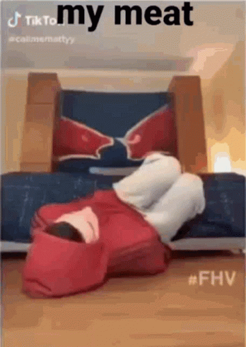 A Person In A Red Hoodie Is Laying On The Floor In Front Of A Couch . GIF