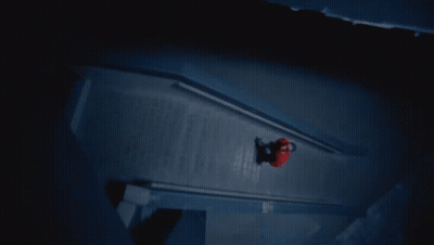 A Person In A Red Shirt Is Walking Down A Dark Staircase GIF