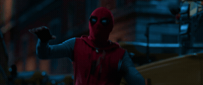 A Person In A Red Spiderman Costume Is Pointing At Something In The Dark GIF