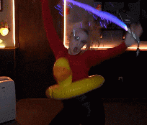 A Person In A Red Sweater Is Holding A Sword And A Yellow Duck Float GIF
