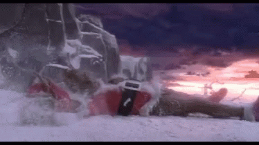 A Person In A Santa Suit Is Laying On A Snowy Hill . GIF