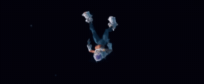 A Person In A Space Suit Is Falling Through The Air In The Dark . GIF
