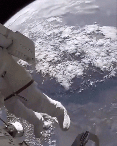 A Person In A Space Suit Is Floating In Space GIF