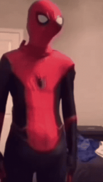 A Person In A Spider Man Costume Is Standing In A Room . GIF