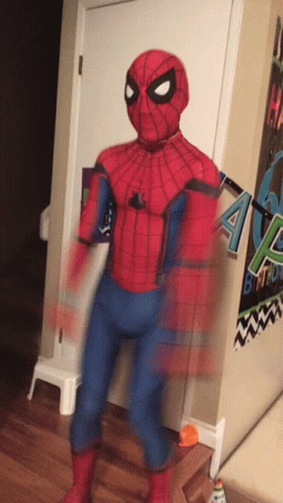 A Person In A Spider Man Costume Is Standing In Front Of A Birthday Banner GIF