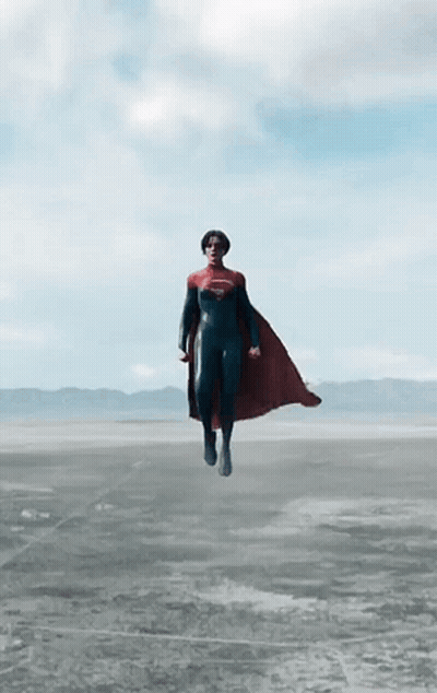 A Person In A Superman Costume Is Flying Through The Air GIF