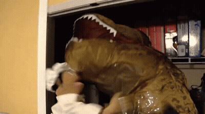 A Person In A T-Rex Costume Reaches Into A Closet Full Of Boxes GIF