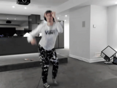 A Person In A Vans Shirt Is Dancing In A Room GIF