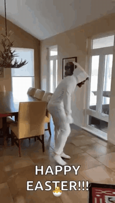 A Person In A White Bunny Suit Is Dancing In A Living Room . GIF
