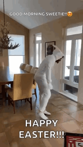 A Person In A White Bunny Suit Is Dancing In A Living Room . GIF