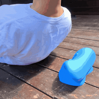 A Person In A White Shirt Is Laying On A Wooden Deck Next To A Blue Object GIF