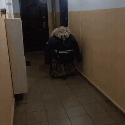 A Person In A Wolf Costume Is Walking Down A Hall GIF