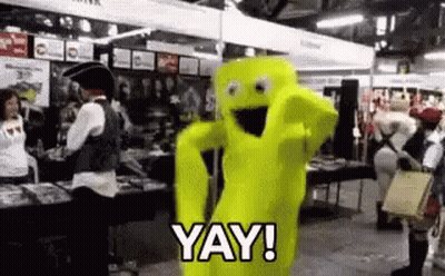 A Person In A Yellow Costume Is Standing In A Crowded Room And Saying `` Yay ! '' GIF