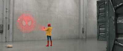 A Person In A Yellow Jacket Is Standing In A Room With A Spider Man Logo On The Wall GIF