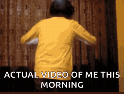 A Person In A Yellow Shirt Is Dancing In Front Of A Window With The Words Actual Video Of Me This Morning GIF