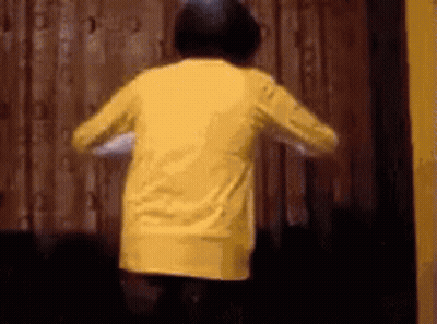 A Person In A Yellow Shirt Is Jumping In The Air . GIF